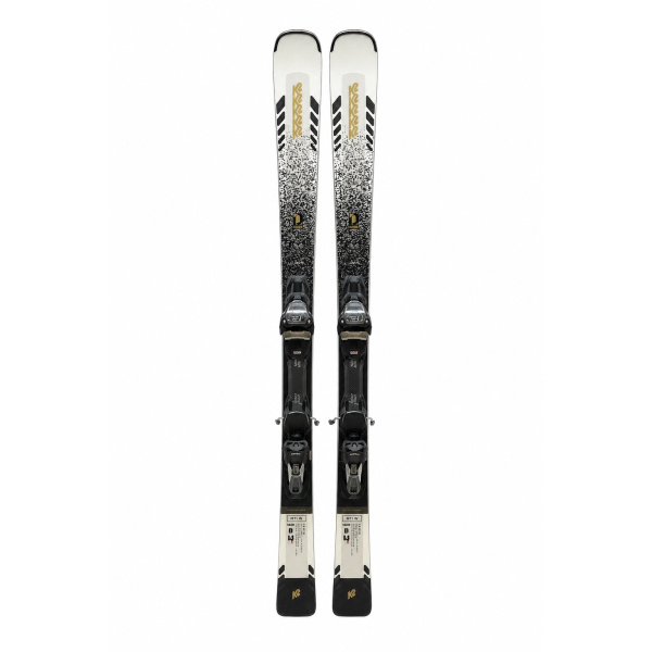 K2 Disruption MTi W 2024 dames carving ski – vooraanzicht van beide ski's met wit, zwart en goud kleurenschema, inclusief Marker ERC 11 TCx systeem bindingen zichtbaar, K2 logo op tip en staart, opgehangen tegen witte achtergrond in skiwinkel