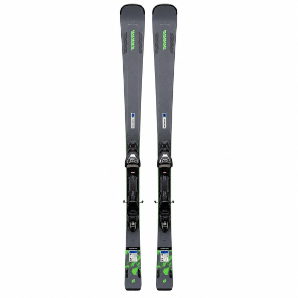K2 Disruption STi ski's volledig aanzicht van voren, grijs met neon groene K2-logo's en Marker GripWalk bindingen, staand tegen een muur in een skiwinkel