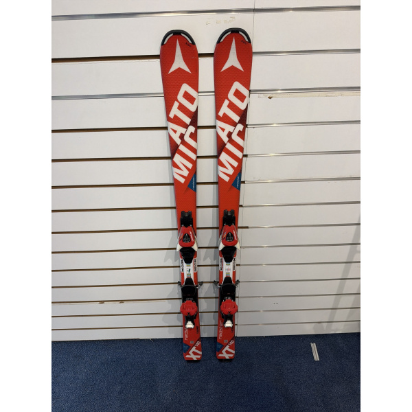 Atomic Redster XT vus du dessus : skis junior rouges avec grande inscription ATOMIC blanche, fixations rouges et moquette bleue en dessous